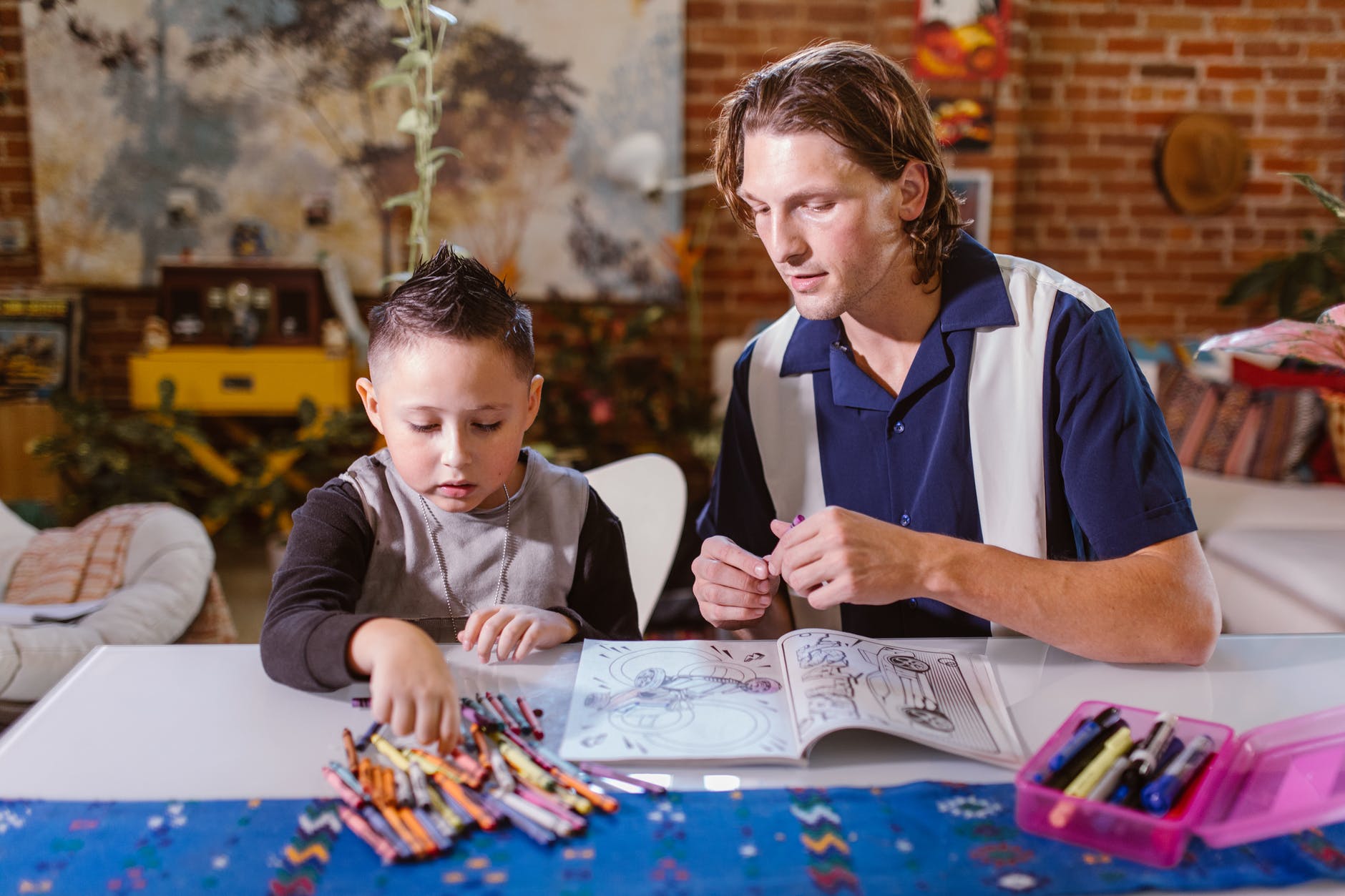 Father helping child read and color